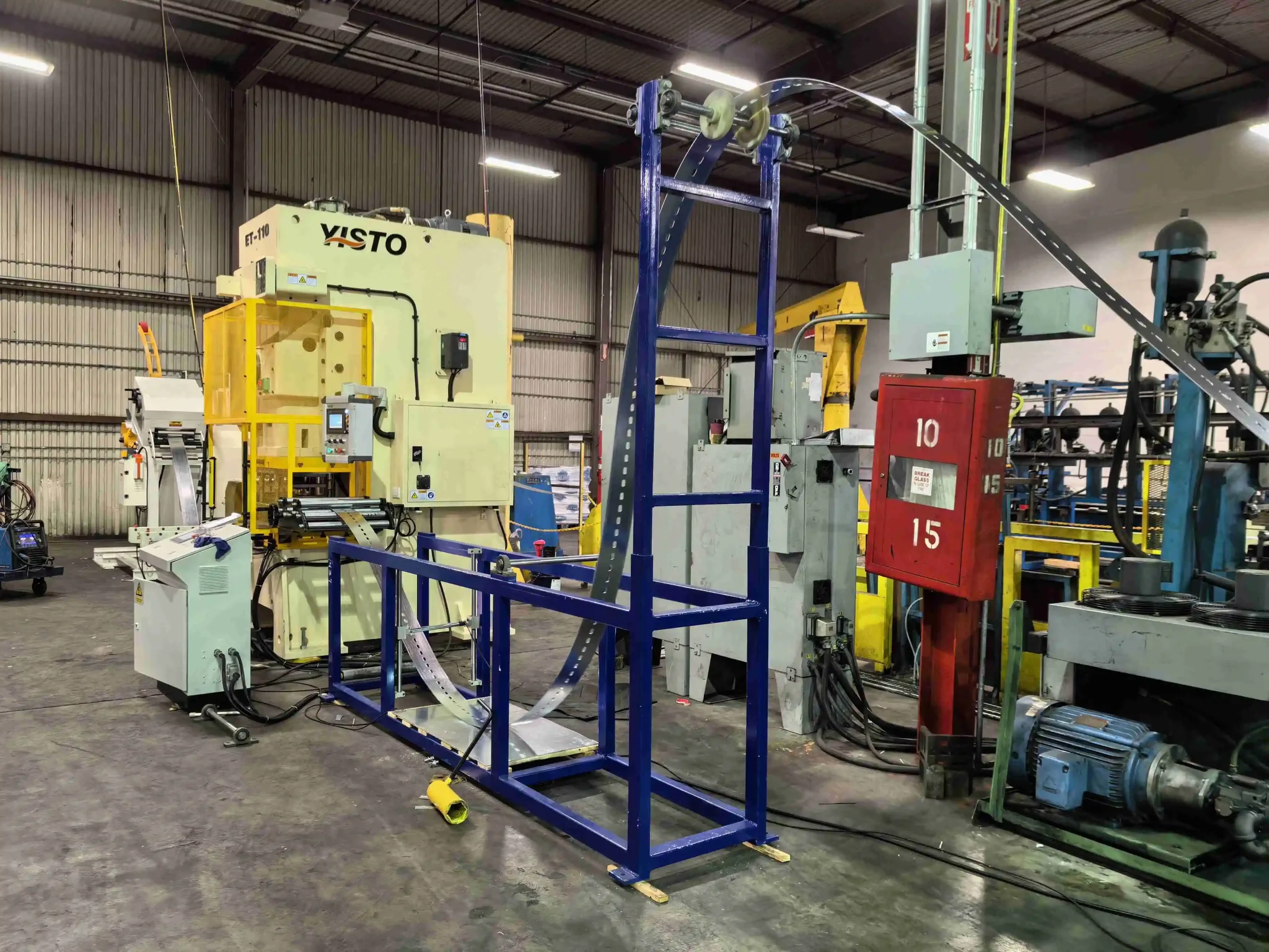 Vetical loop accumulator holding material between punch and roll forming