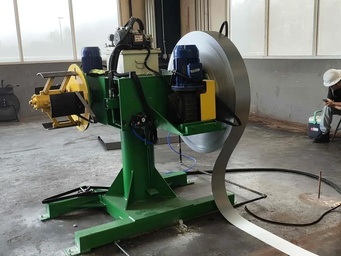 A double-header uncoiler (dual-mandrel uncoiler) system, feeding two separate steel coils alternately into the roll forming line for continuous operation without stopping for coil changes.