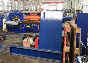 A heavy-duty industrial hydraulic uncoiler shown holding a large steel coil, indicating the starting point of the roll forming process.