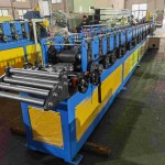 Système d'alimentation et de guidage réglable sur machine de profilage à rouleaux en C.