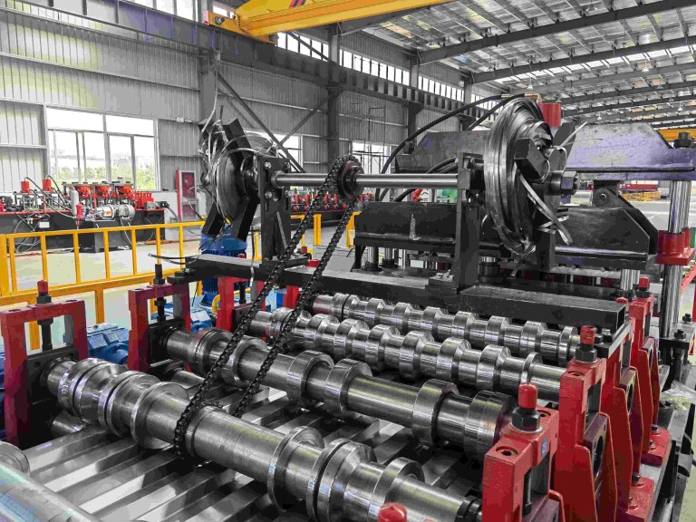 Close up of rollers on heavy-duty container wall panel roll forming machine.