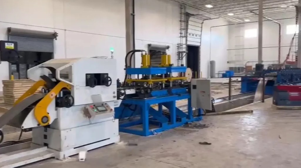 Close-up of servo feeder and hydraulic punching device on sigma purlin roll forming machine.