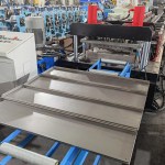 "Beli’s shelf panel roll forming machine mid-operation: The modular roll former (16–24 GCr15 steel rollers) shaping flat steel into ribbed shelving panels—adding strength for heavy retail loads