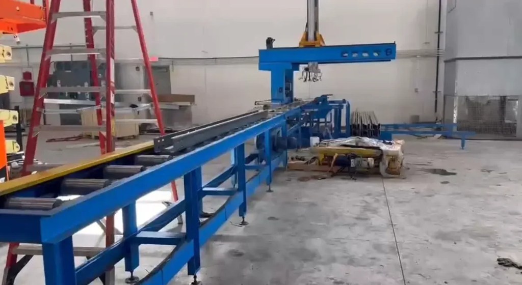 Automated stacker collecting finished sigma purlins from a roll forming machine.