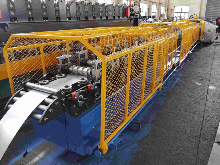 Long line of roll forming stands gradually shaping a metal strip into a door frame