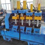 Post cutter and puncher performing final cuts and hydraulic punching on newly formed door frame sections.